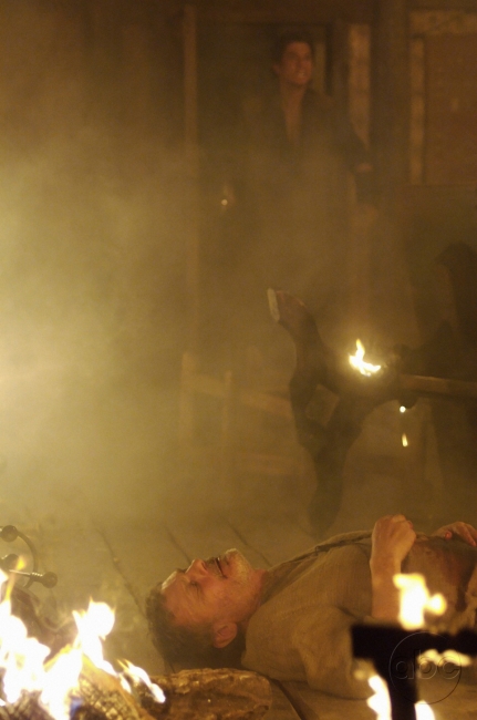 George Cypher (Jeffrey Thomas) inconscient au milieu des flammes